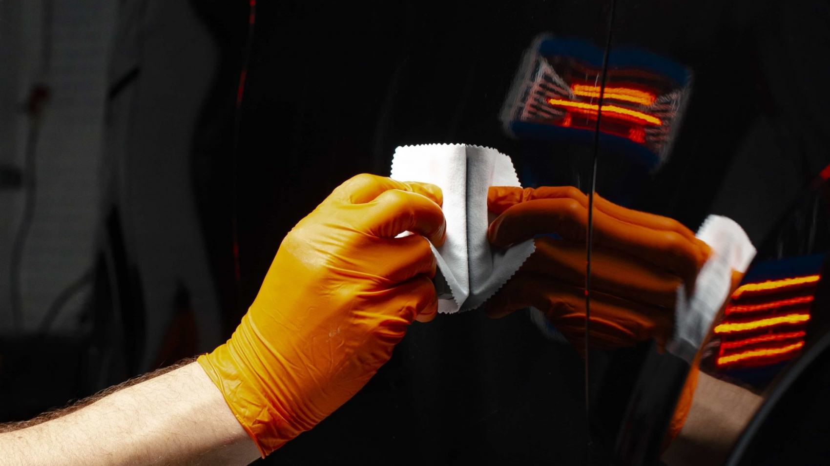 Car polish wax worker hands polishing car. Buffing and polishing vehicle with ceramic. Car detailing. Man holds a polisher in the hand and polishes the car with nano ceramic. Tools for polishing