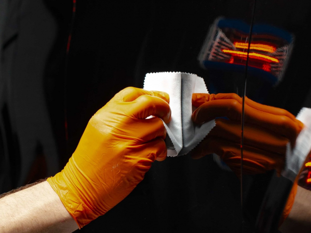 Car polish wax worker hands polishing car. Buffing and polishing vehicle with ceramic. Car detailing. Man holds a polisher in the hand and polishes the car with nano ceramic. Tools for polishing