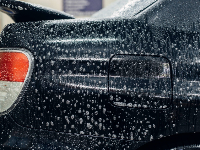 Carwash service, car in foam, side view. Auto detailing, high pressure contactless washing on special station