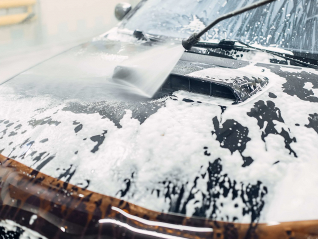 Carwash service, car cleaning, top view on hood. Auto detailing, washing foam off